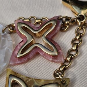 Close-up of the marbled resin and gold-tone Monogram outlines on the Louis Vuitton Insolence charms