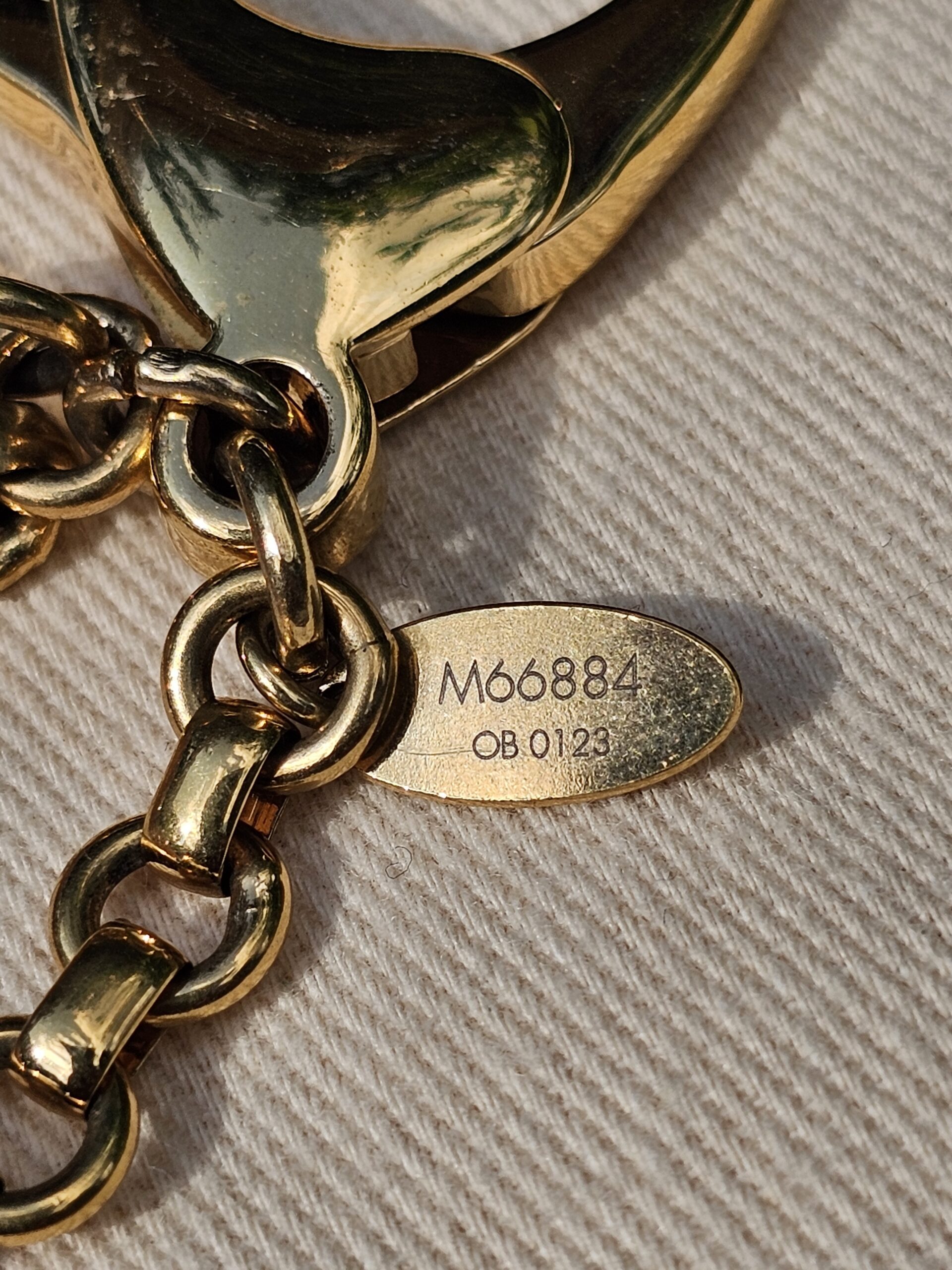 Plaque stamped M66884 and date code OB0123 on the Louis Vuitton Insolence bag charm