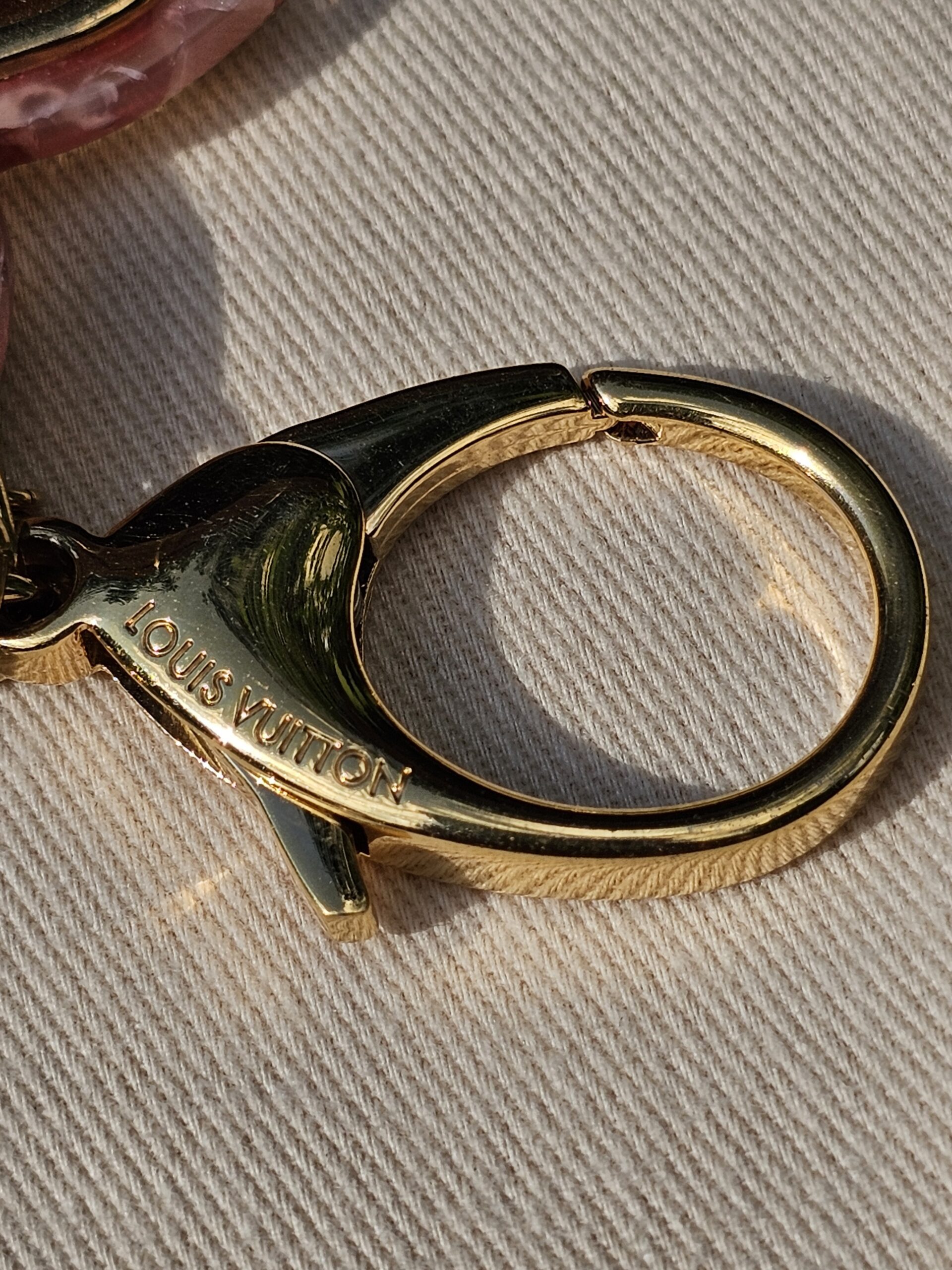 Gold-tone lobster clasp and key ring on the Louis Vuitton Insolence key holder and bag charm