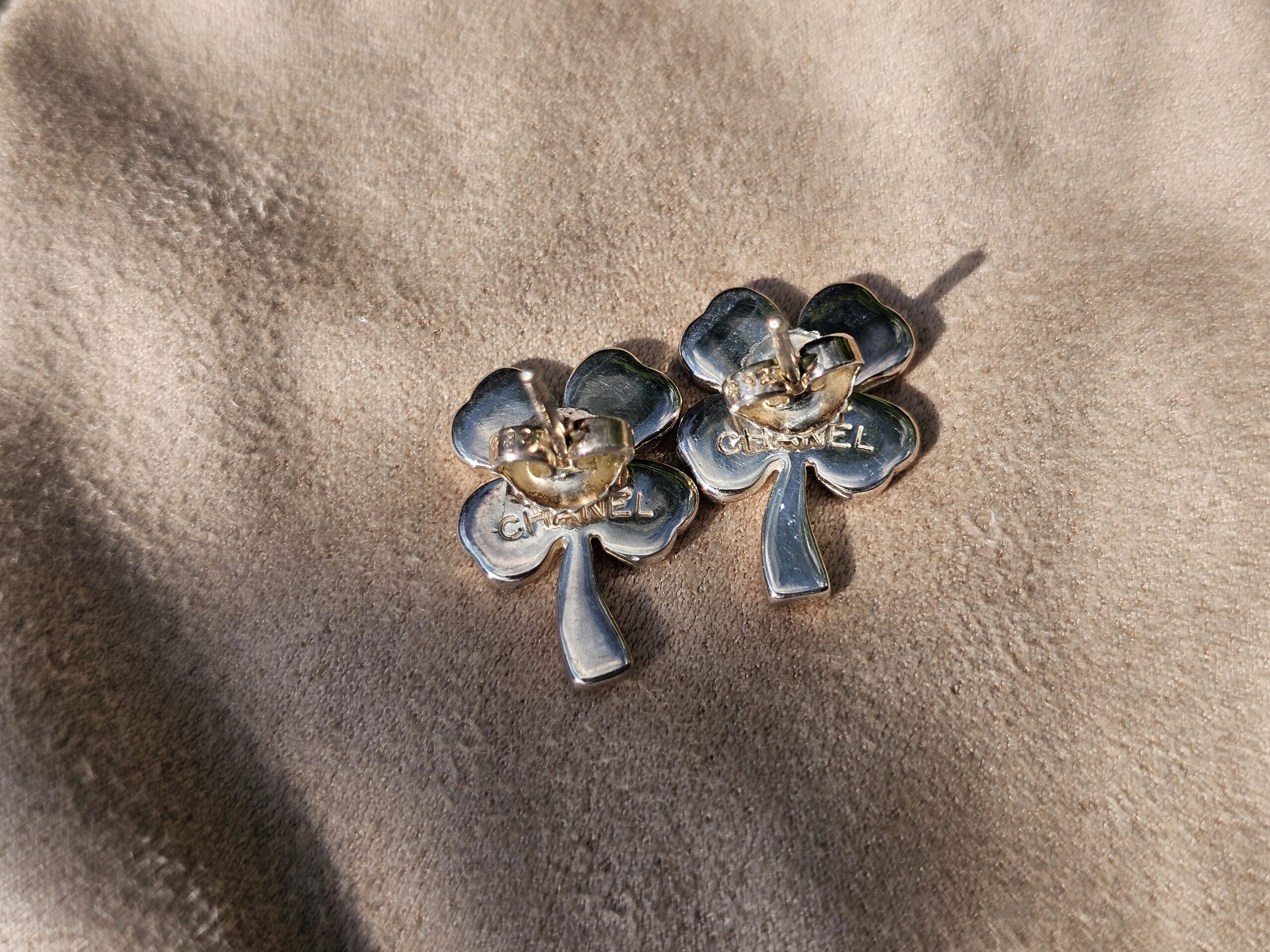 Chanel four leaf clover stud earrings shown with their earring backs attached
