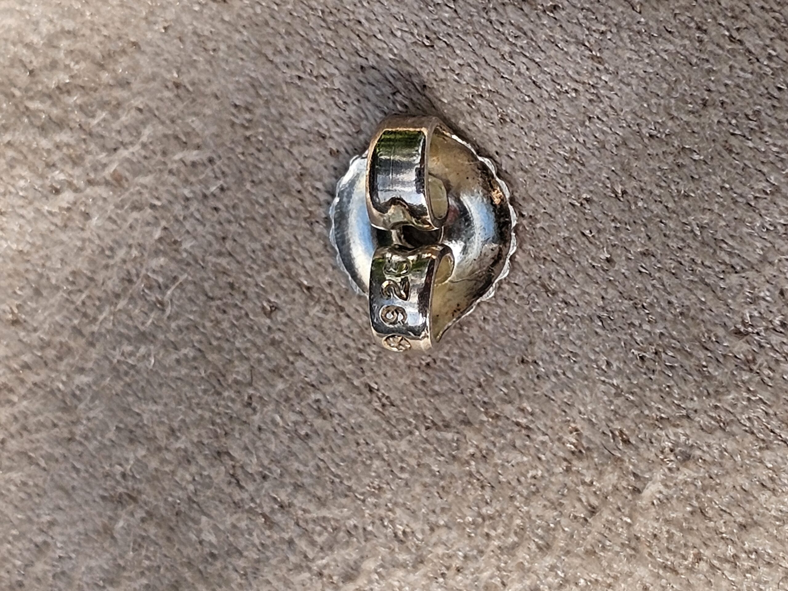 Reverse of a Chanel four leaf clover stud earring showing the post and back