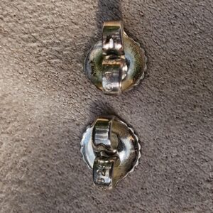Backs of the Chanel four leaf clover stud earrings shown for wear from previous use