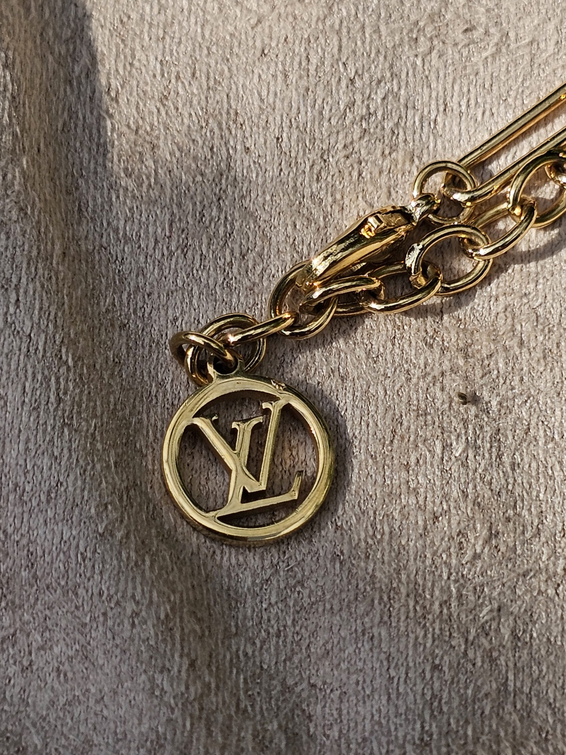 Gold-tone LV medallion charm on the Louis Vuitton Sweet Monogram bracelet
