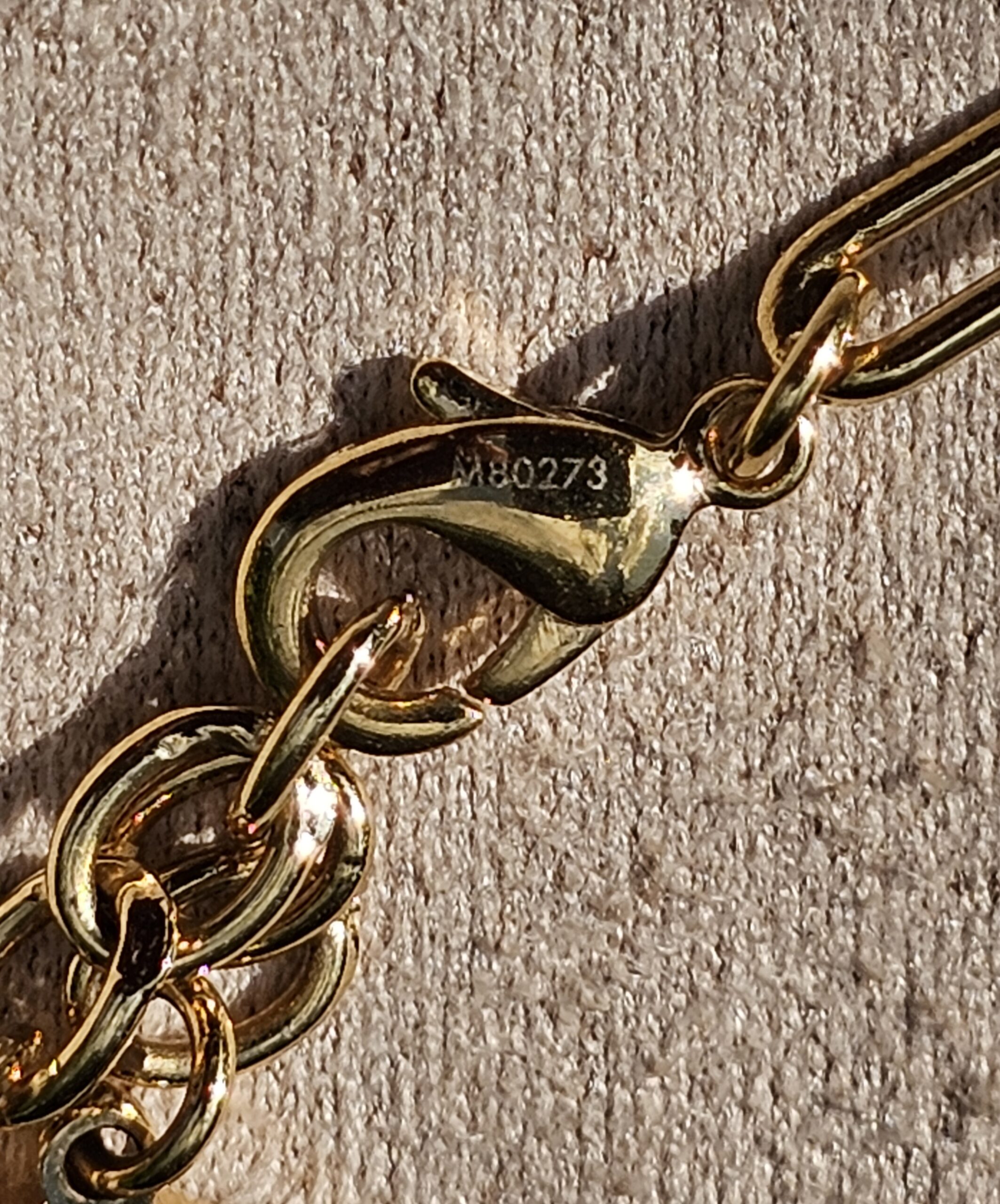 Style M80273 stamped near the lobster clasp of the Louis Vuitton Sweet Monogram bracelet