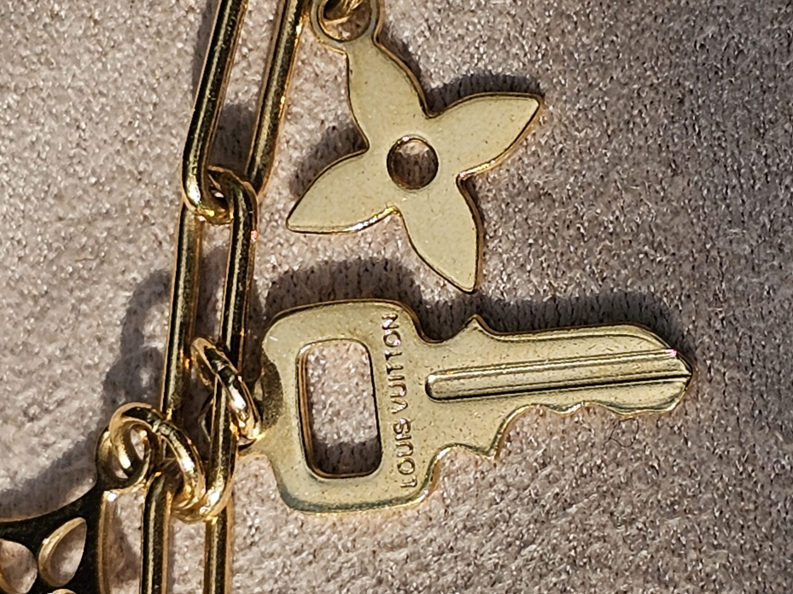 Key charm engraved Louis Vuitton alongside the Monogram flower charm on the Sweet Monogram bracelet