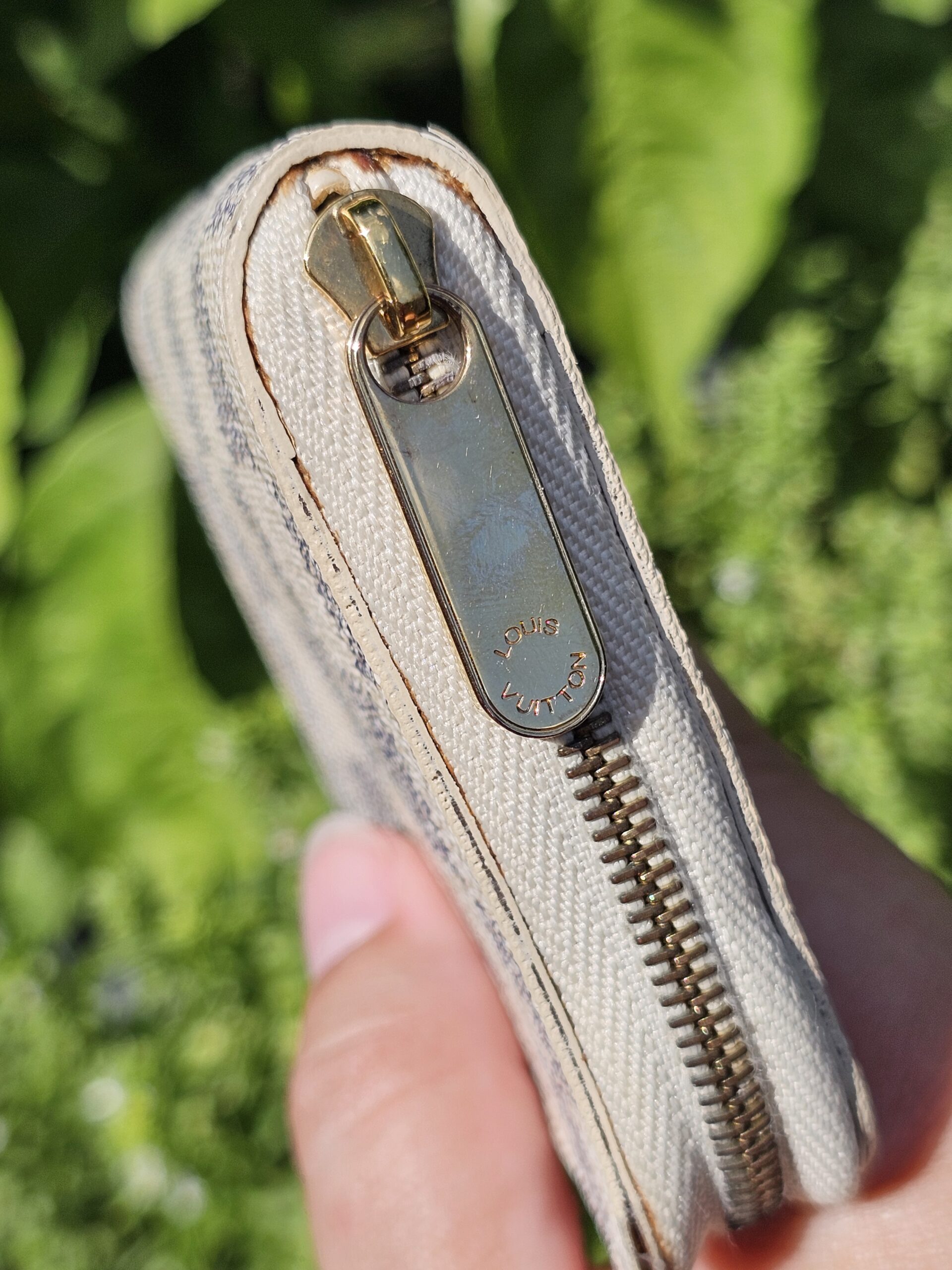 Close-up of the gold-tone zip and hardware on the Louis Vuitton Damier Azur Zippy Coin Purse