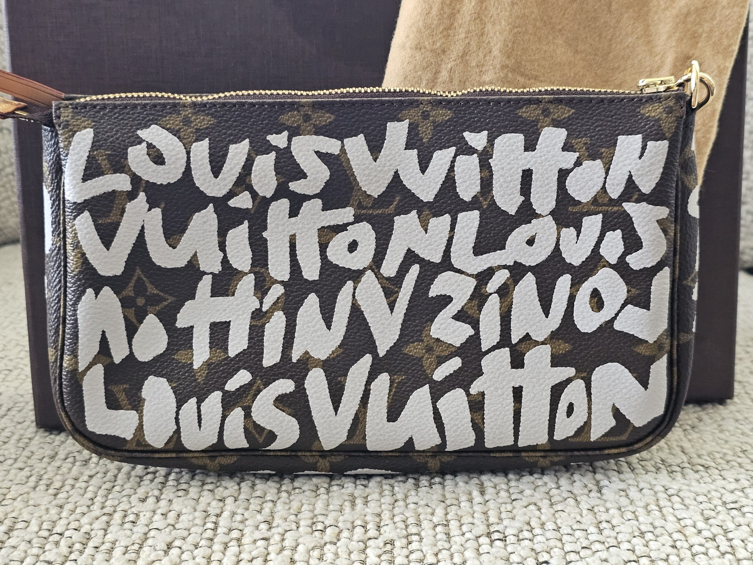 Front of the Louis Vuitton Graffiti Pochette Accessoires showing the white Stephen Sprouse lettering over Monogram canvas