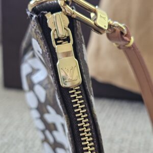 Gold-tone LV zip pull and vachetta strap on the Stephen Sprouse Graffiti Pochette Accessoires