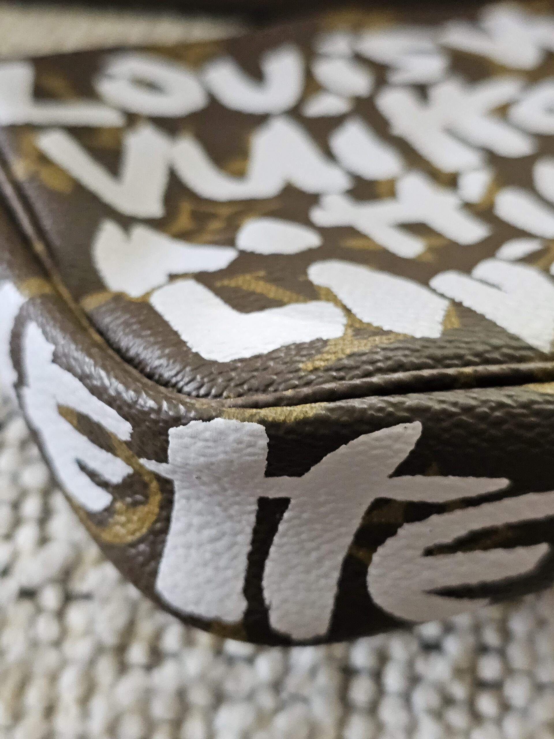 Close-up of the white Stephen Sprouse graffiti print over Louis Vuitton Monogram canvas