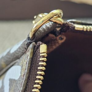 Gold-tone zip and hardware on the Louis Vuitton Graffiti Pochette Accessoires