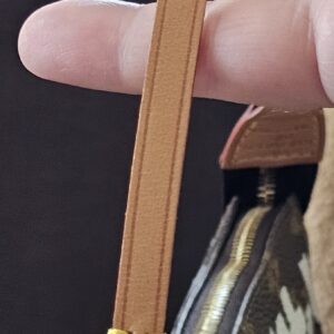 Gold-tone clasp attaching the vachetta wrist strap to the Louis Vuitton Graffiti Pochette Accessoires