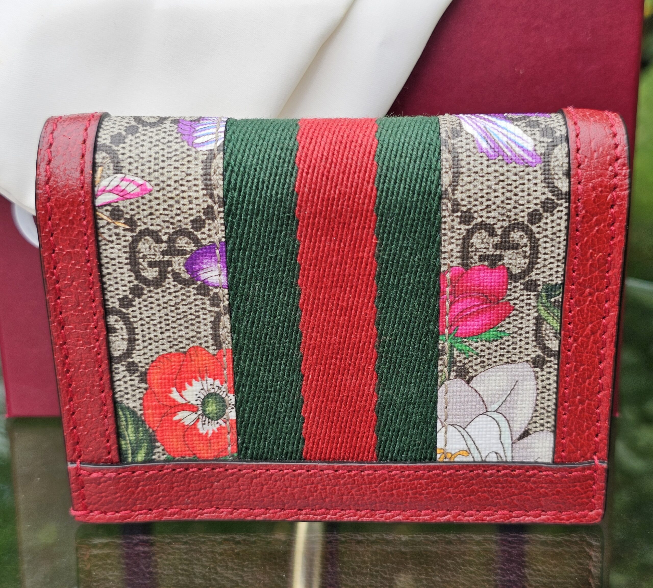Back of the Gucci Ophidia compact wallet showing the GG Supreme canvas with Flora floral print