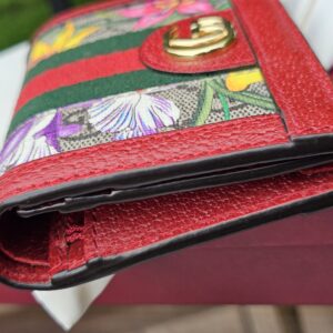Angled view of the Gucci GG Supreme Flora Ophidia compact wallet with Double G closure