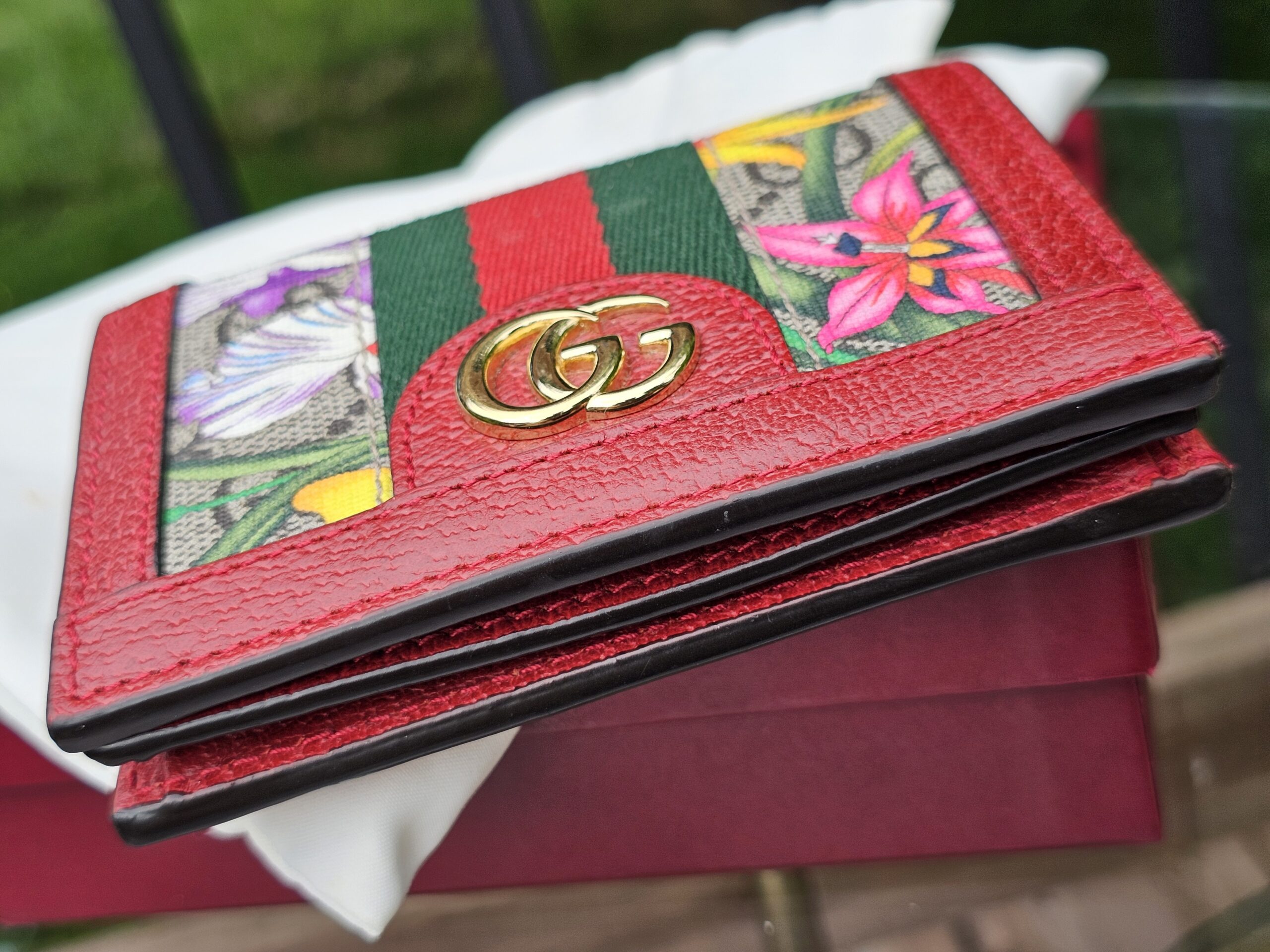 Gold-tone Double G hardware on the front of the Gucci Flora Ophidia compact wallet