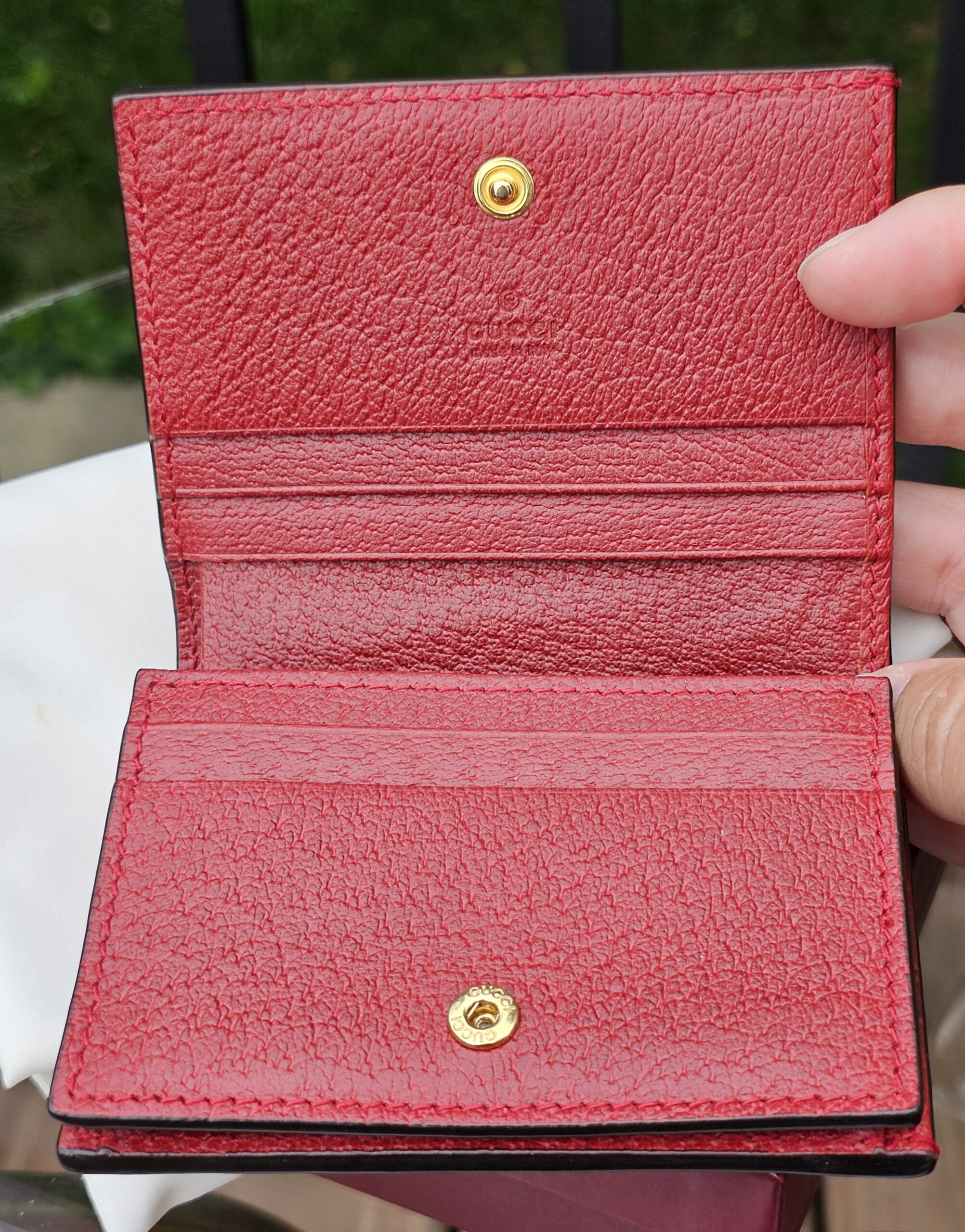 Red leather interior of the Gucci Ophidia compact wallet with card slots and compartments