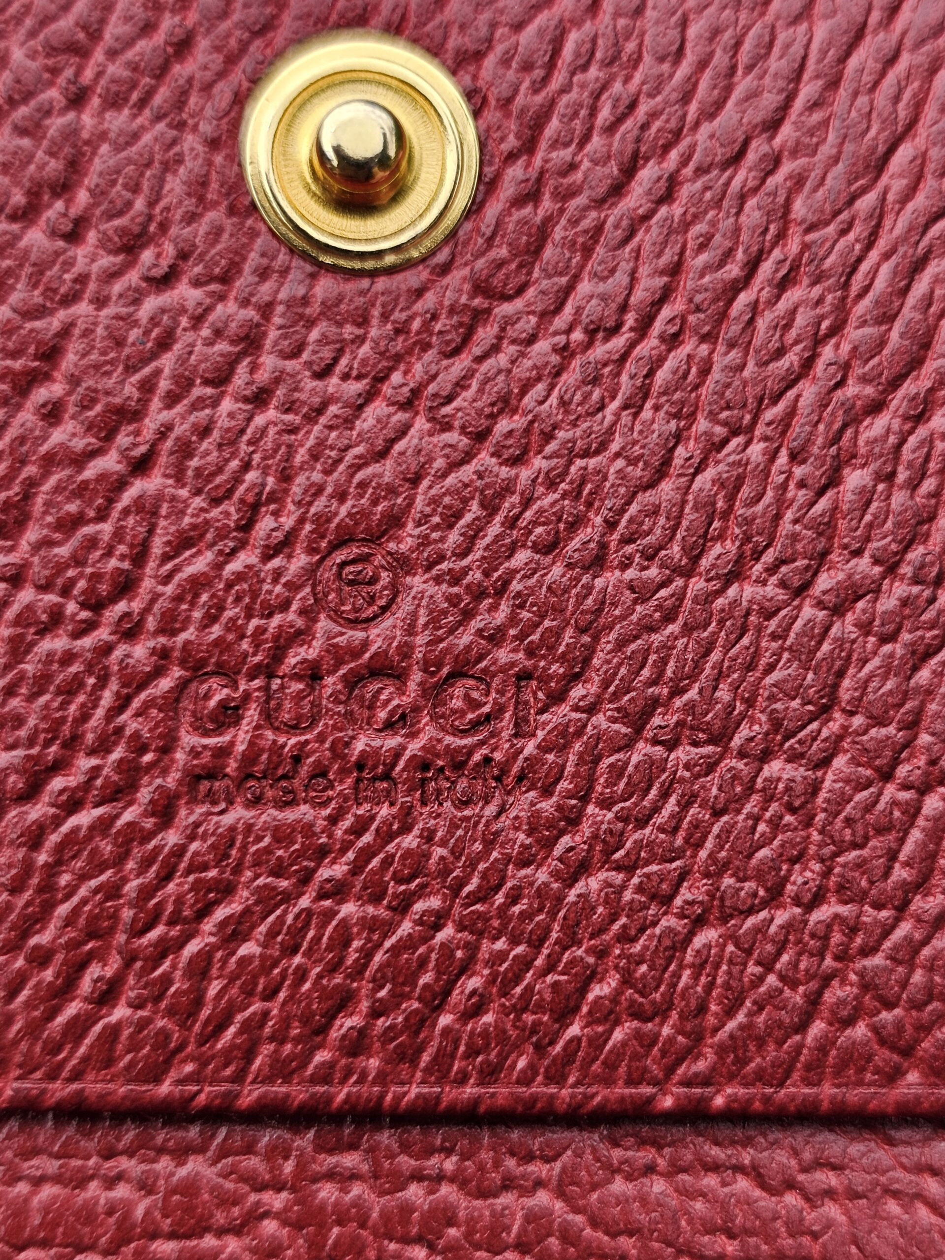Gucci made in Italy stamp embossed on the red leather interior of the Ophidia wallet