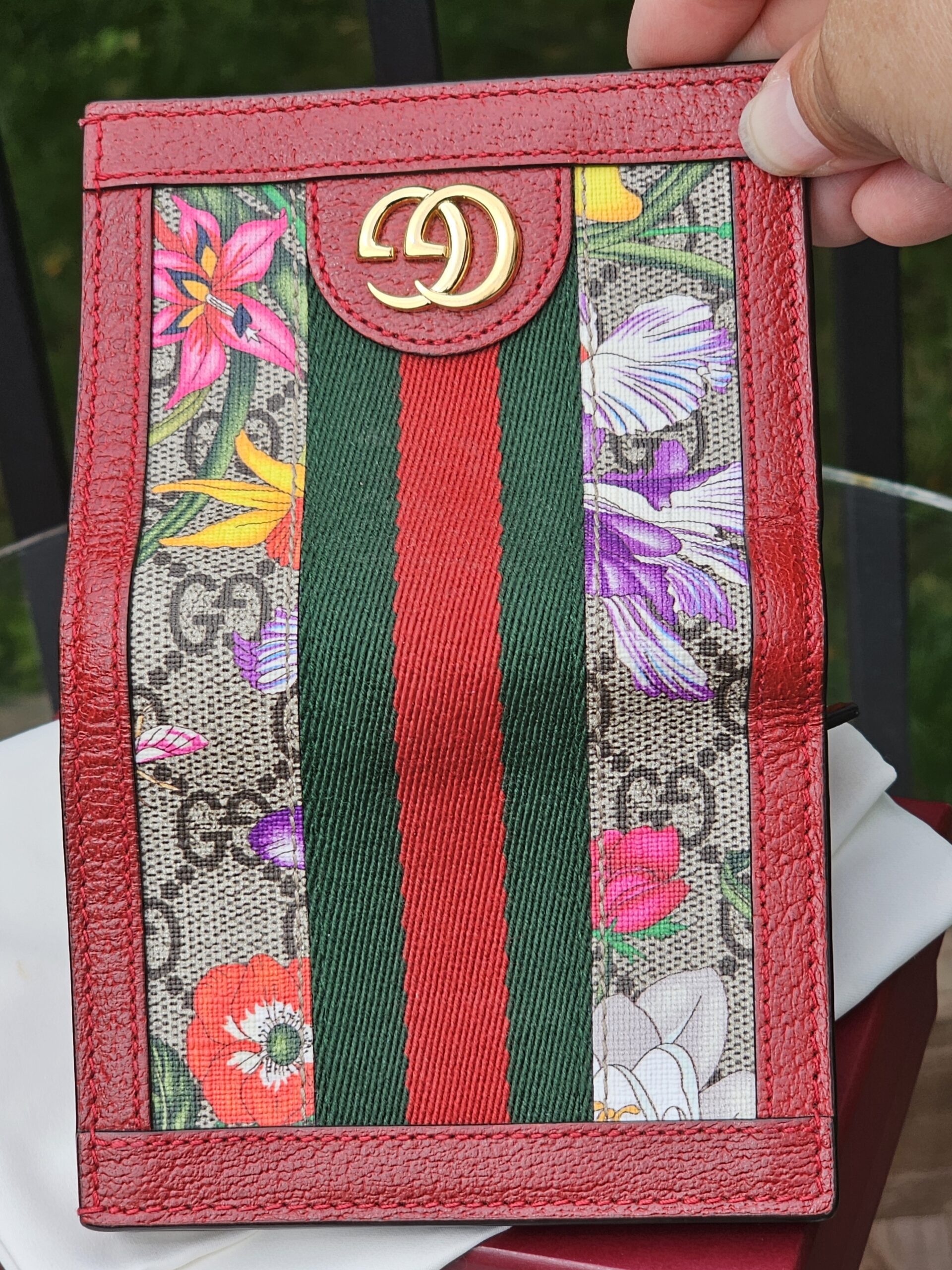 Gucci GG Supreme Flora Ophidia compact wallet held in hand to show scale