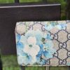 Gucci compact wallet in GG Supreme canvas with blue Blooms floral print, shown with its Gucci box