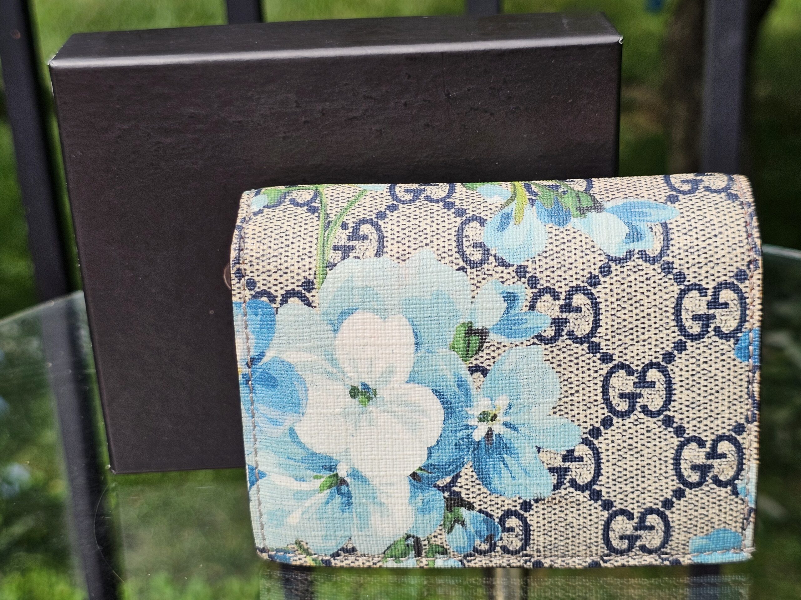 Gucci compact wallet in GG Supreme canvas with blue Blooms floral print, shown with its Gucci box