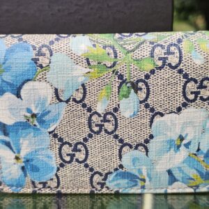 Front of the Gucci GG Supreme Blooms compact wallet showing the blue floral print over GG canvas