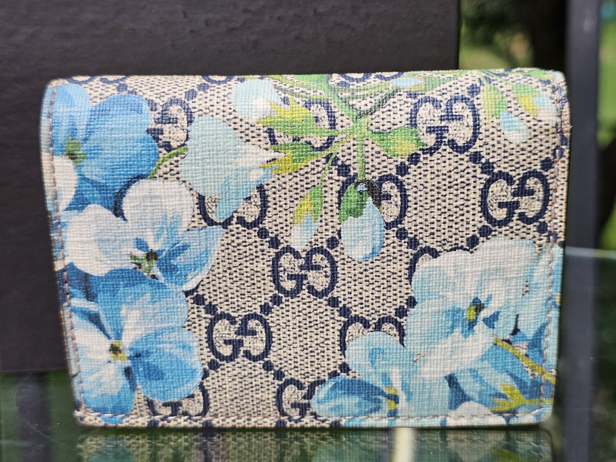 Front of the Gucci GG Supreme Blooms compact wallet showing the blue floral print over GG canvas