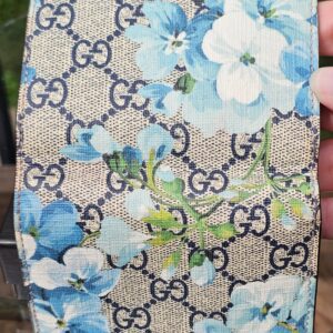 Gucci GG Supreme Blooms compact wallet held in hand to show scale