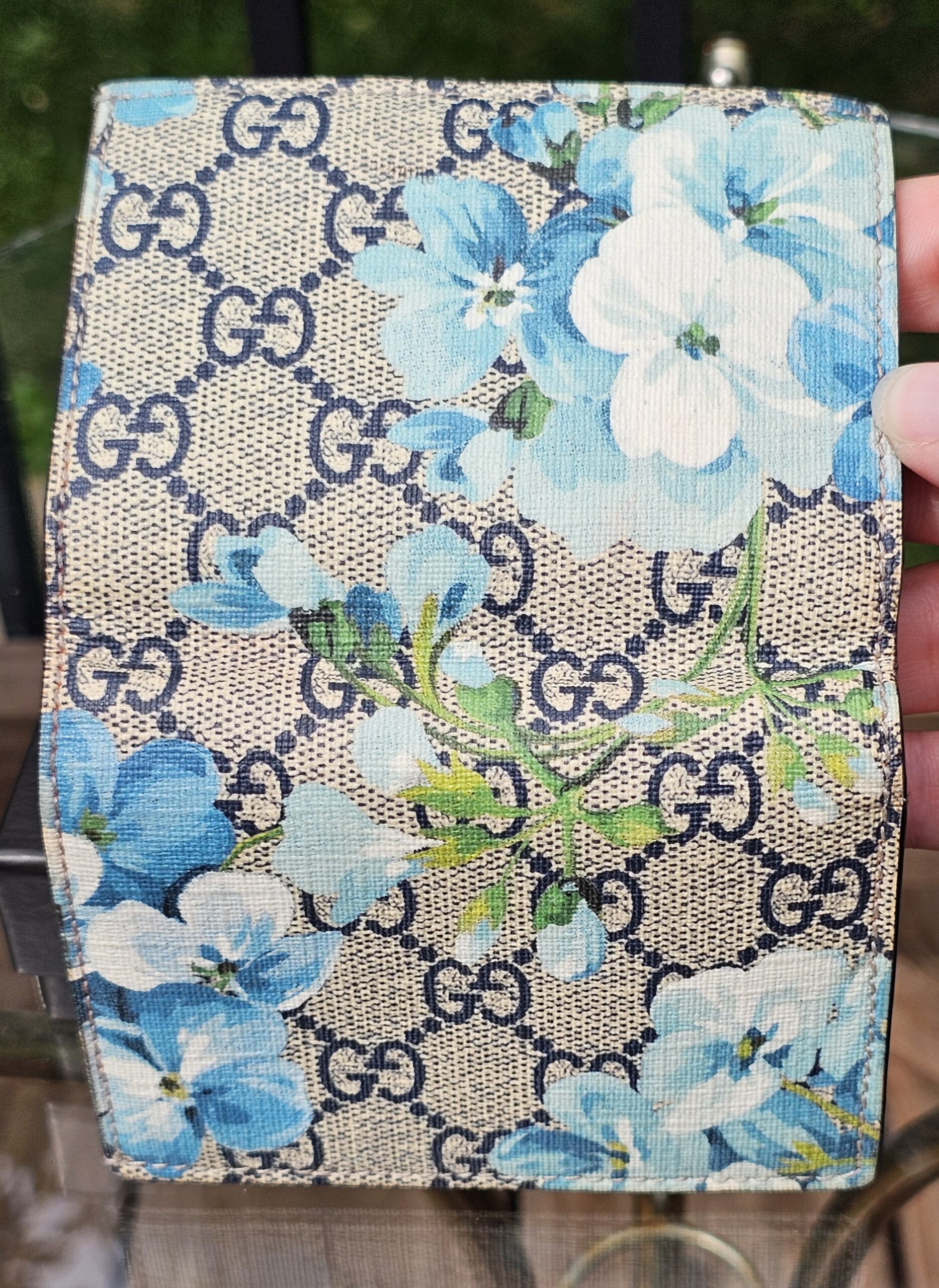 Gucci GG Supreme Blooms compact wallet held in hand to show scale