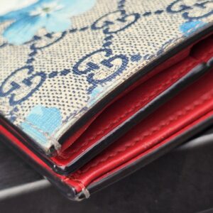 Card slots and red leather interior of the Gucci GG Supreme Blooms compact wallet