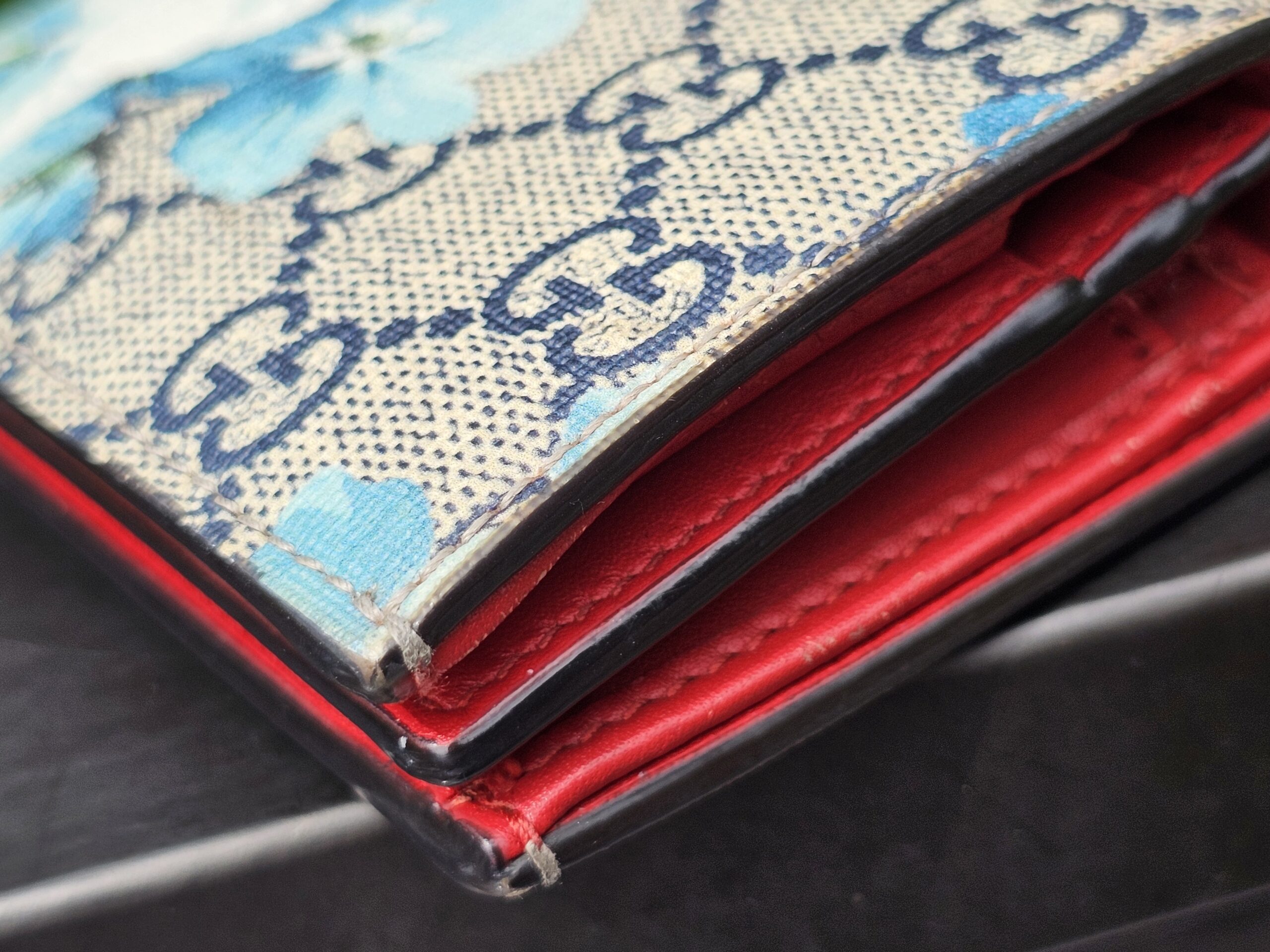 Card slots and red leather interior of the Gucci GG Supreme Blooms compact wallet
