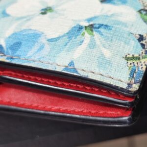 Edges of the Gucci Blooms compact wallet shown for minor rubbing from previous use