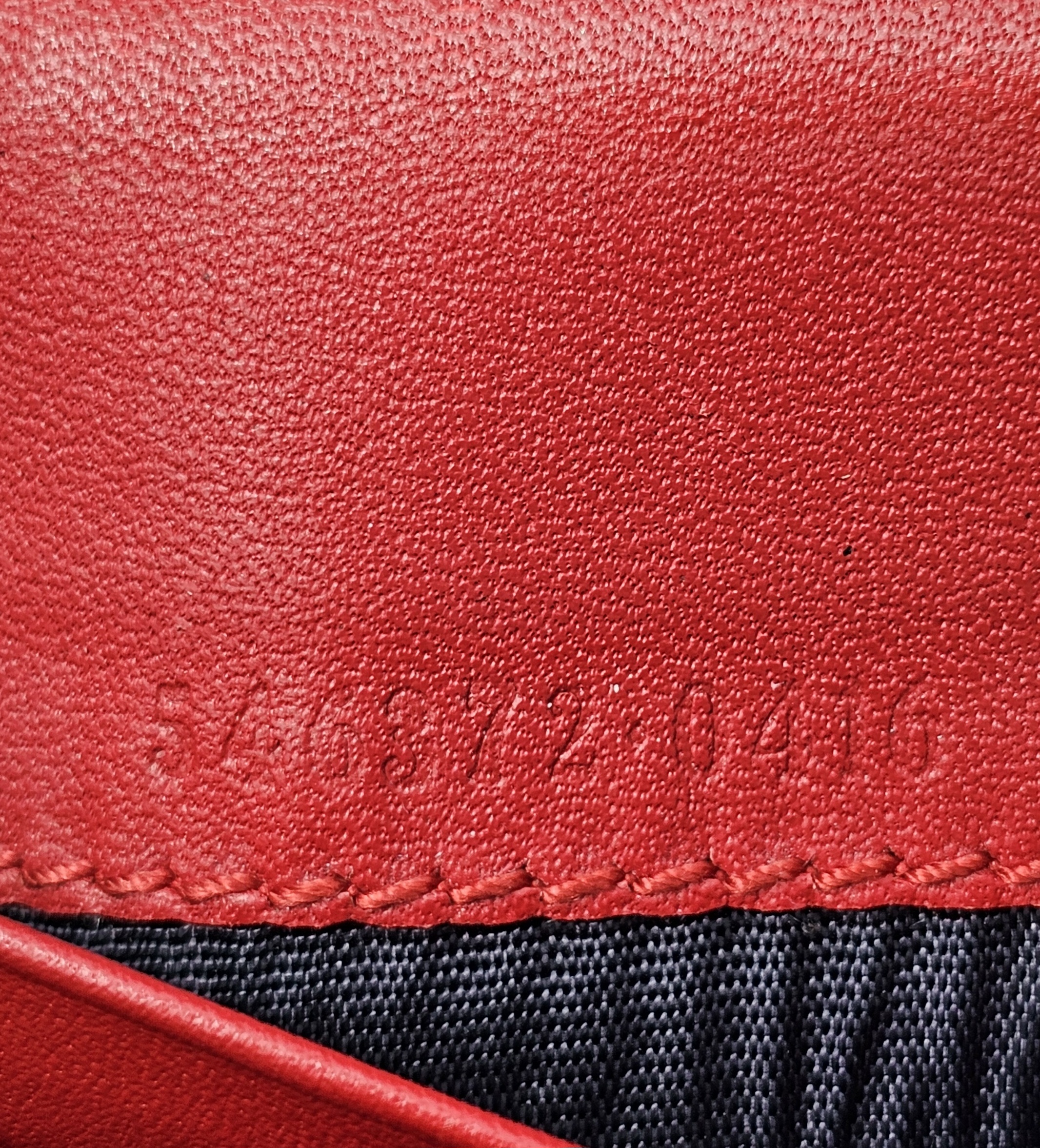 Style code embossed on the red leather inside the Gucci Blooms compact wallet