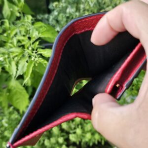 Gucci Flora Ophidia compact wallet held open showing the red leather and black lined coin compartment