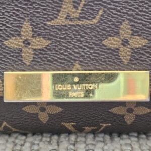 Gold-tone Louis Vuitton Paris plate on the flap of the Favorite PM