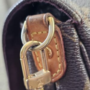 Gold-tone clasp and vachetta tab on the Louis Vuitton Favorite PM