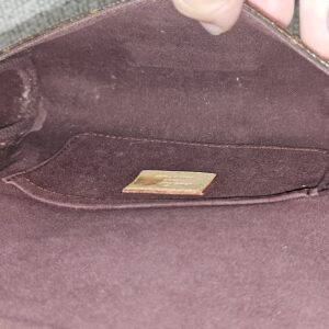 Burgundy textile interior of the Louis Vuitton Favorite PM showing marks from previous use