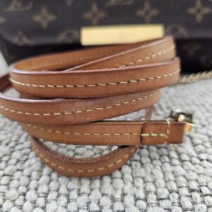 Vachetta strap of the Louis Vuitton Favorite PM coiled beside the bag