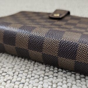 Side profile of the Louis Vuitton Medium Ring Agenda showing the snap tab