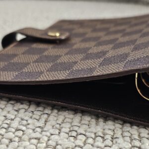 Gold-tone 6-ring binder hardware inside the Louis Vuitton Damier Ebene agenda