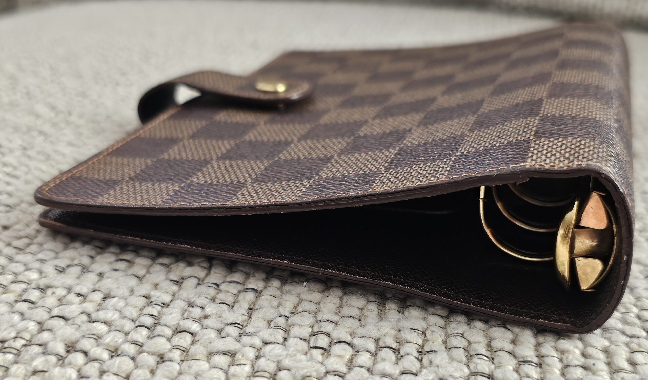 Gold-tone 6-ring binder hardware inside the Louis Vuitton Damier Ebene agenda
