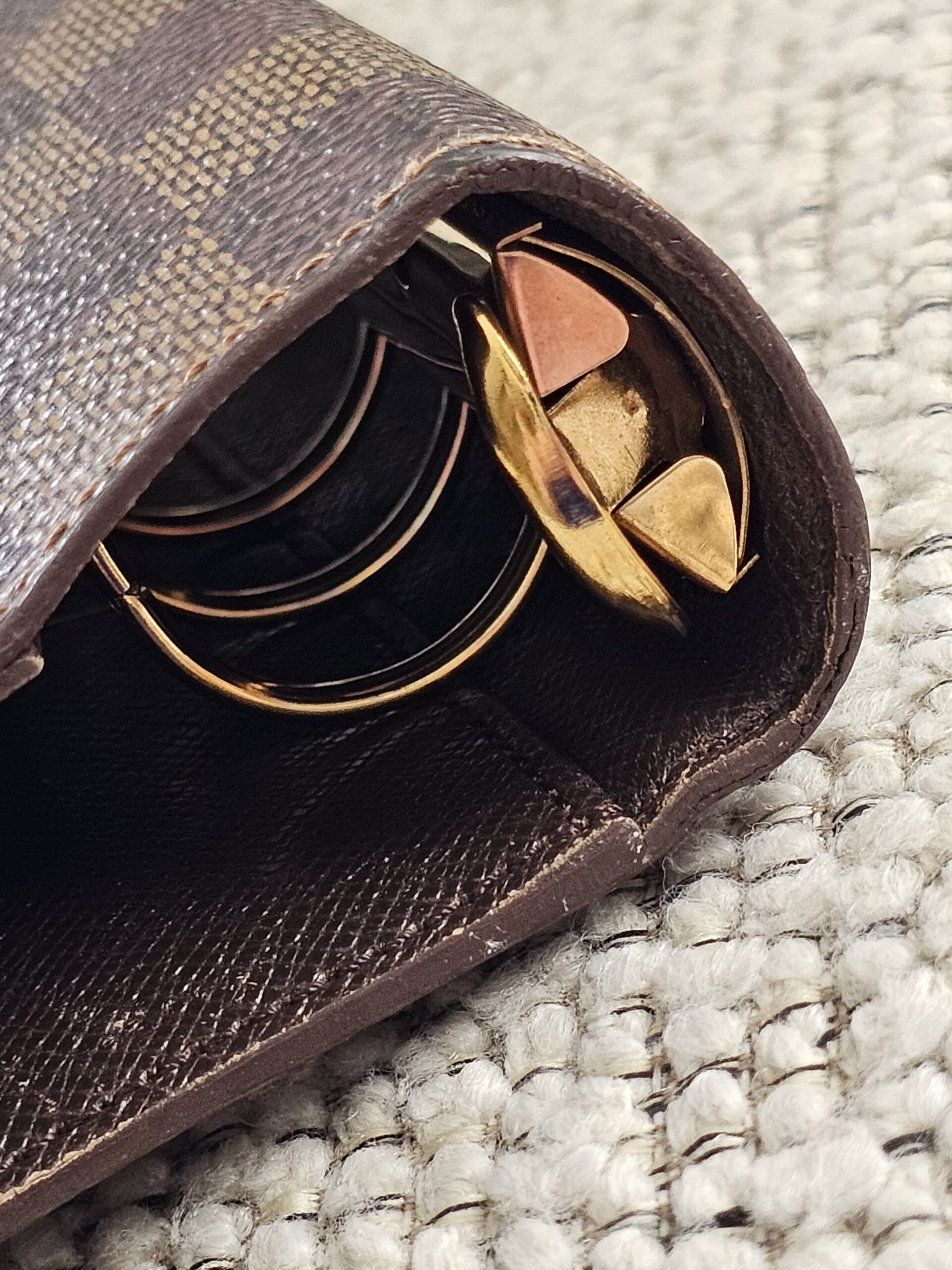 Gold-tone ring mechanism of the Louis Vuitton Damier Ebene agenda