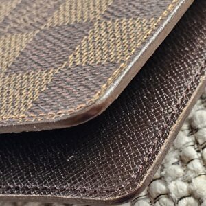 Edge of the Louis Vuitton Damier Ebene agenda shown for light wear from age