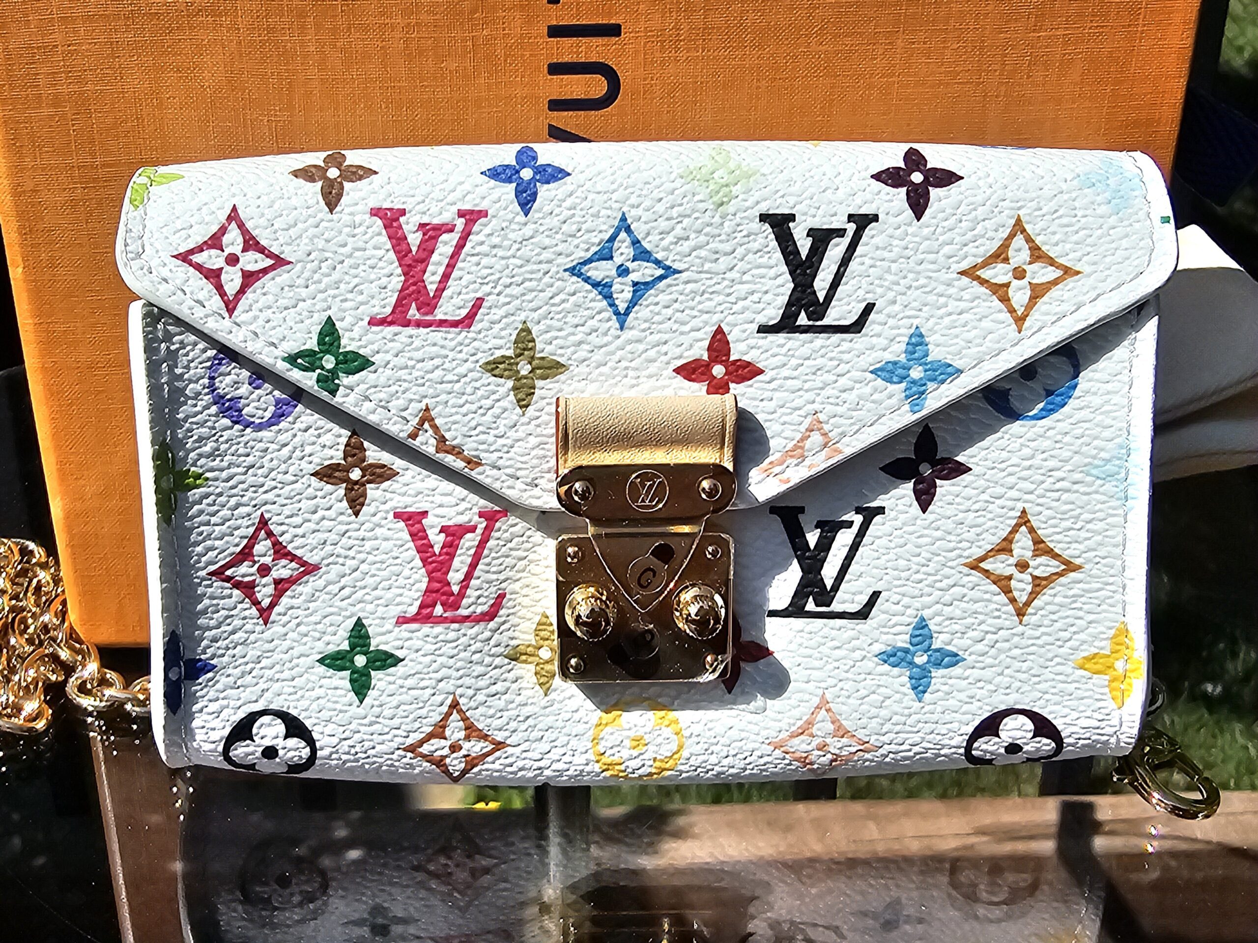 Front of the white Monogram Multicolor pouch with the S-lock closure