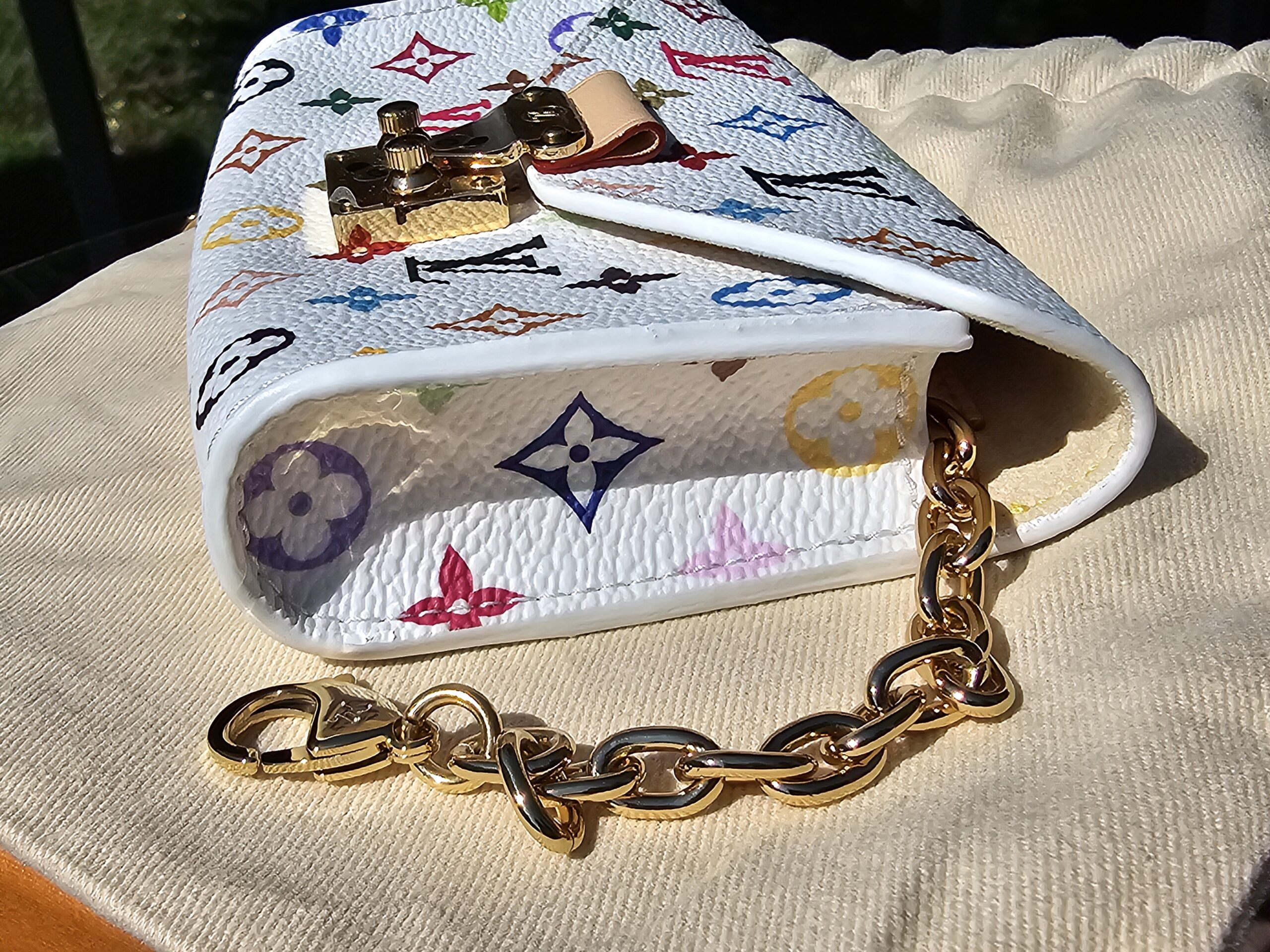 Side of the pouch with the gold-tone chain on the dust bag