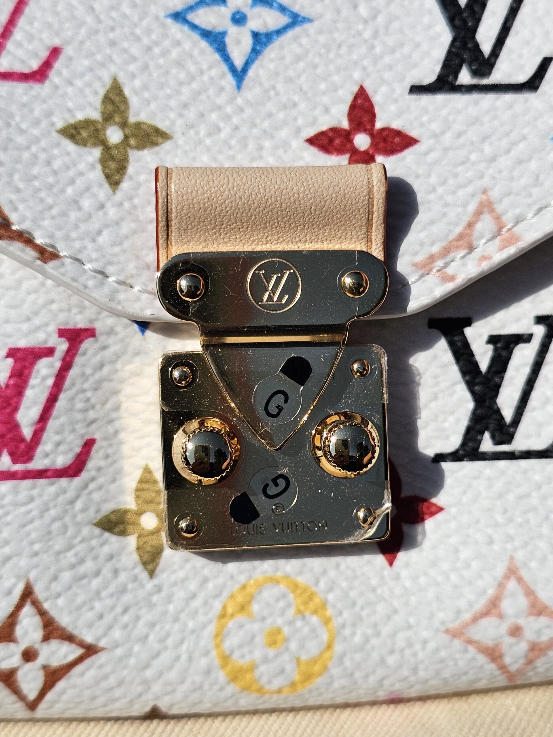 Gold-tone S-lock closure with its vachetta tab on the Multicolor canvas