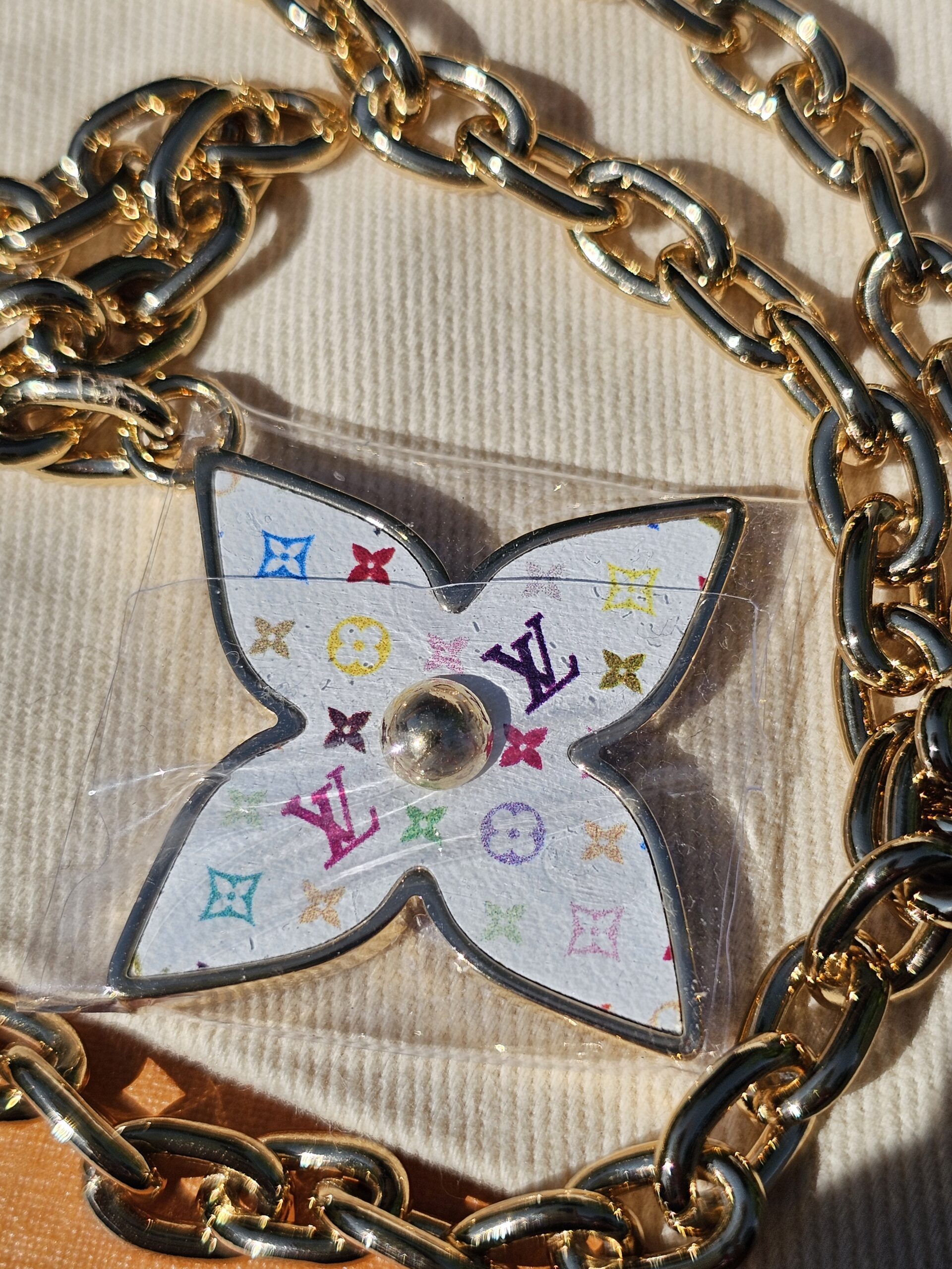 Close-up of the Multicolor Flowergram charm still in protective film