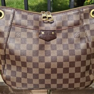 Front of the Louis Vuitton South Bank Besace showing the Damier Ebene checkered canvas and front slip pocket
