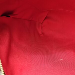Clean red textile interior of the Louis Vuitton South Bank Besace