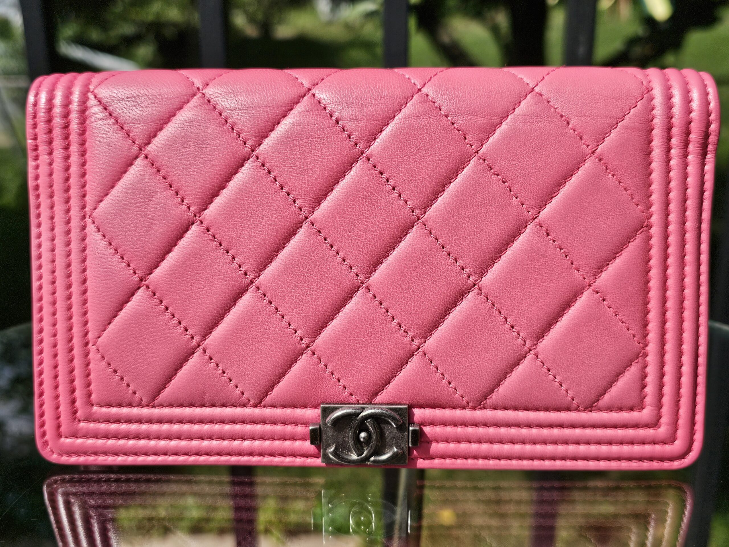 Front of the Chanel Boy long wallet in vibrant pink quilted leather with the ruthenium Boy CC clasp