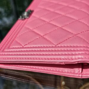 Angled view of the pink Chanel Boy long wallet with the flap closed