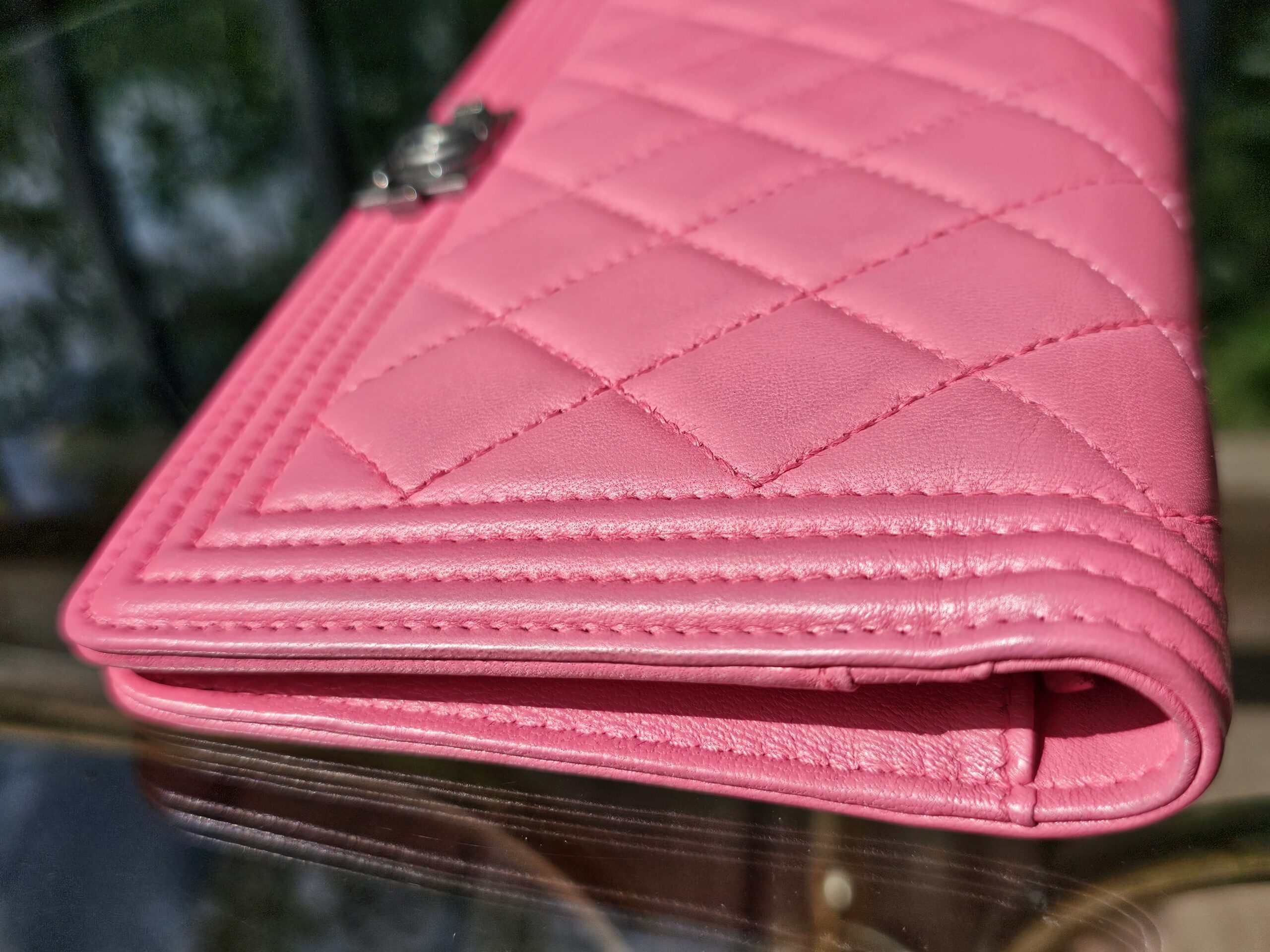 Angled view of the pink Chanel Boy long wallet with the flap closed